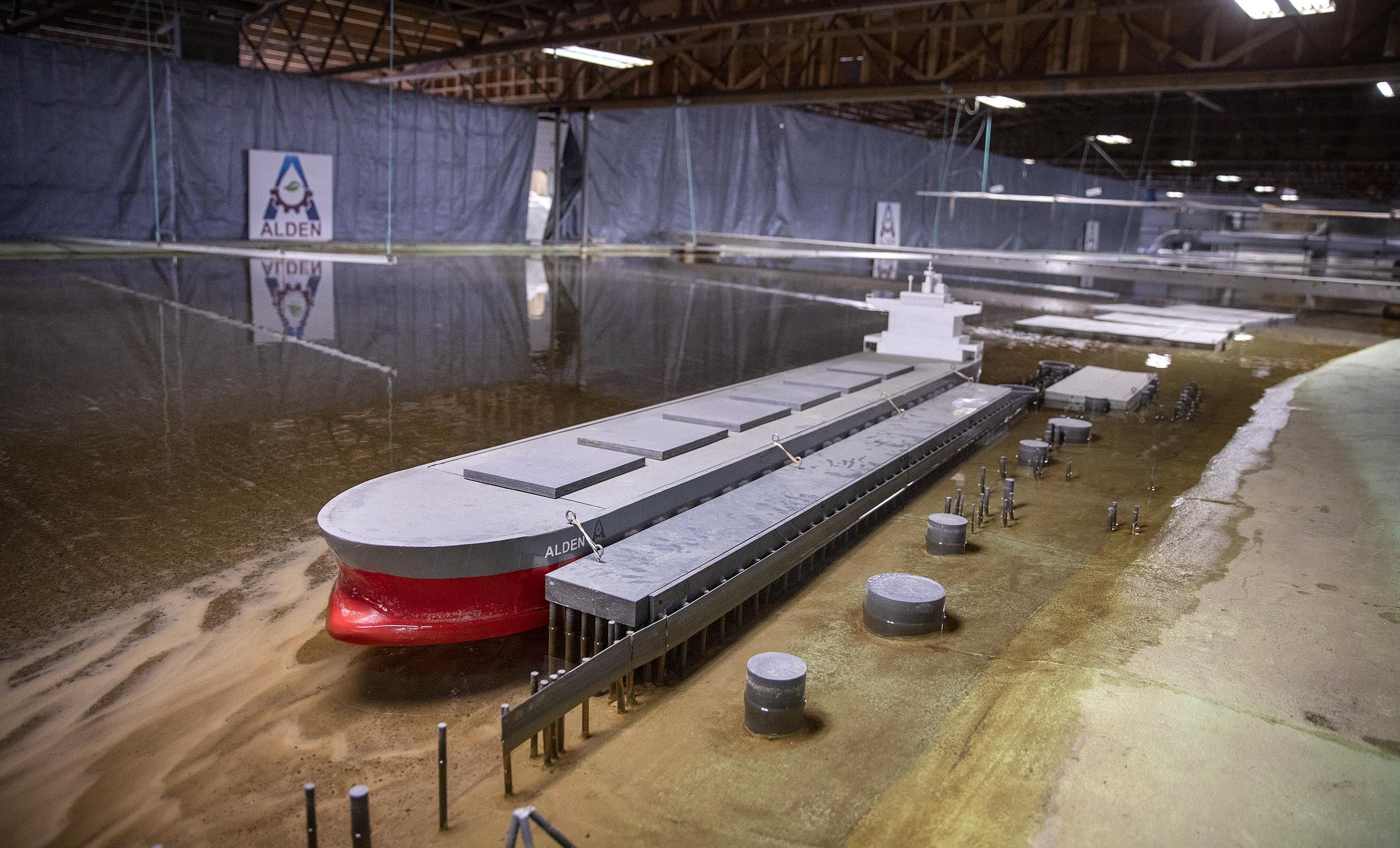 A cargo vessel lies docked on the banks of Alden's 1:65 scale model of a section of the Mississippi River. (Robin Lubbock/WBUR)