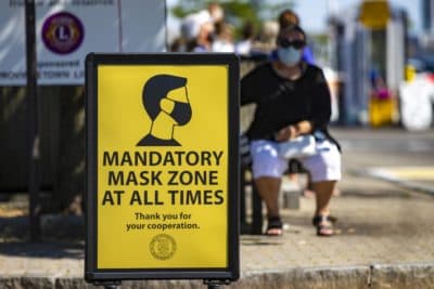 Signs are posted around the business district of Provincetown reminding everyone to wear a mask in public to help prevent the spread of coronavirus. (Jesse Costa/WBUR)