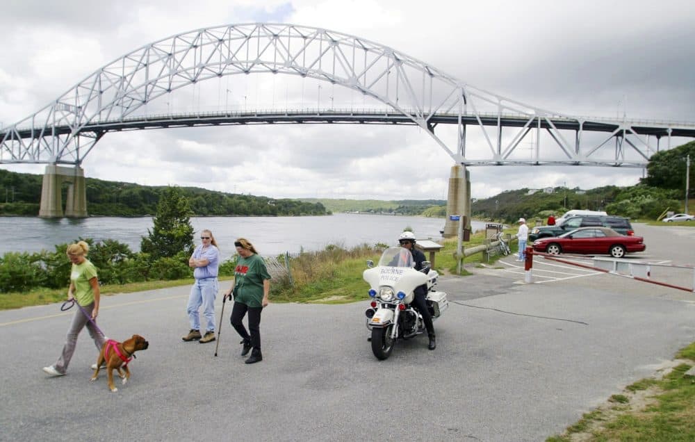 In this Sept. 9, 2003 photo, a police officer patrols as pedestrians walk along the Cape Cod Canal beneath the Sagamore bridge in Bourne, Mass. (Julia Cumes/AP)