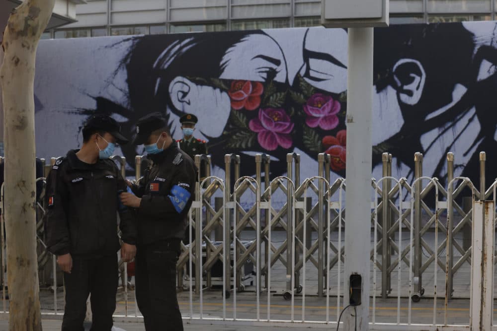 Chinese security personnel stand on duty near an art work outside the United States Embassy in Beijing on April 6, 2021. China accused the U.S. of causing humanitarian disasters through foreign military interventions in a report Friday, April 9, 2021 that was the latest broadside by Beijing amid increasingly contentious relations with the Biden administration. (Ng Han Guan/Associated Press)