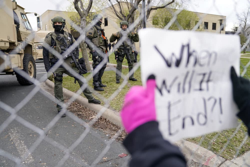 Police stand guard as demonstrators gather outside the Brooklyn Center Police Department to protest the shooting death of Daunte Wright, Tuesday, April 13, 2021, in Brooklyn Center, Minn. (John Minchillo/AP)
