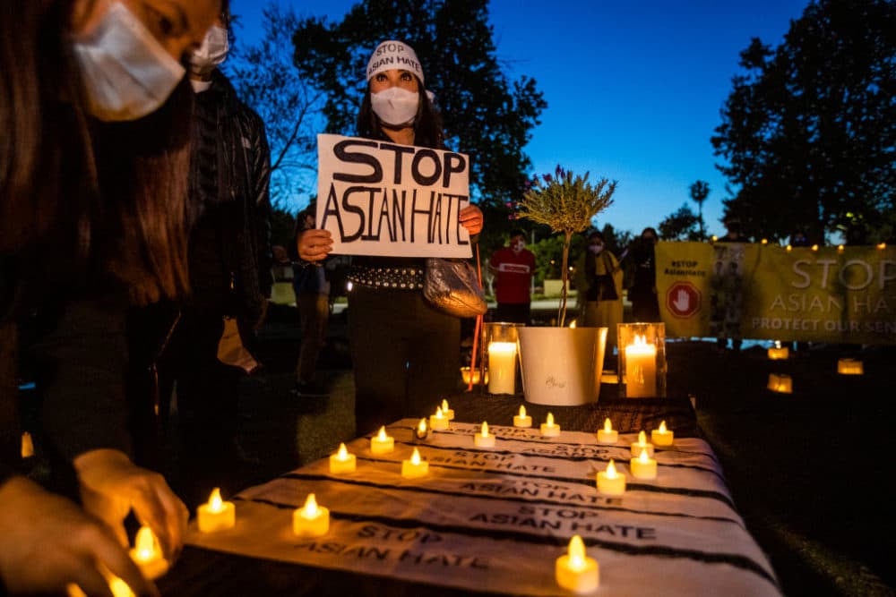 Vanessa Nguyen holds a Stop Asian Hate sign while joining community leaders during a candlelight vigil mourning the victims of the Atlanta shootings, in Garden Grove, CA, on March 23, 2021. (Allen J. Schaben / Los Angeles Times via Getty Images)