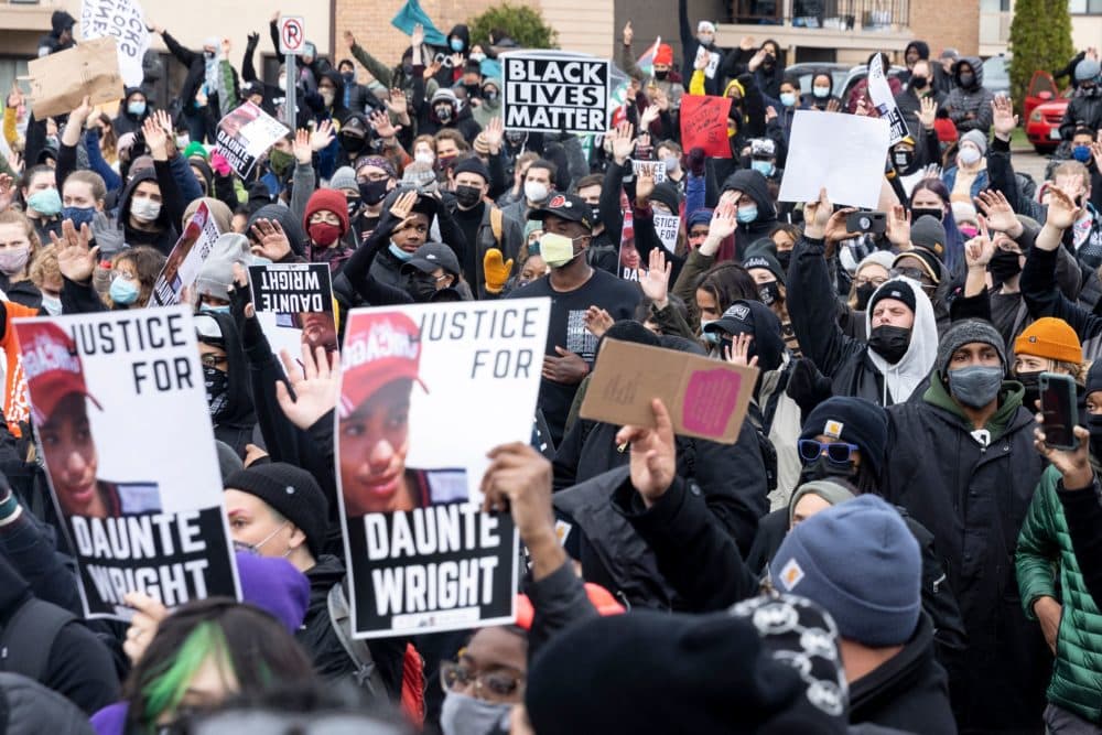 People gather holding pictures of Daunte Wright along with Black Lives Matter signs to protest his death by a police officer in Brooklyn Center, Minnesota on April 12. (Kerem Yucel/AFP via Getty Images)