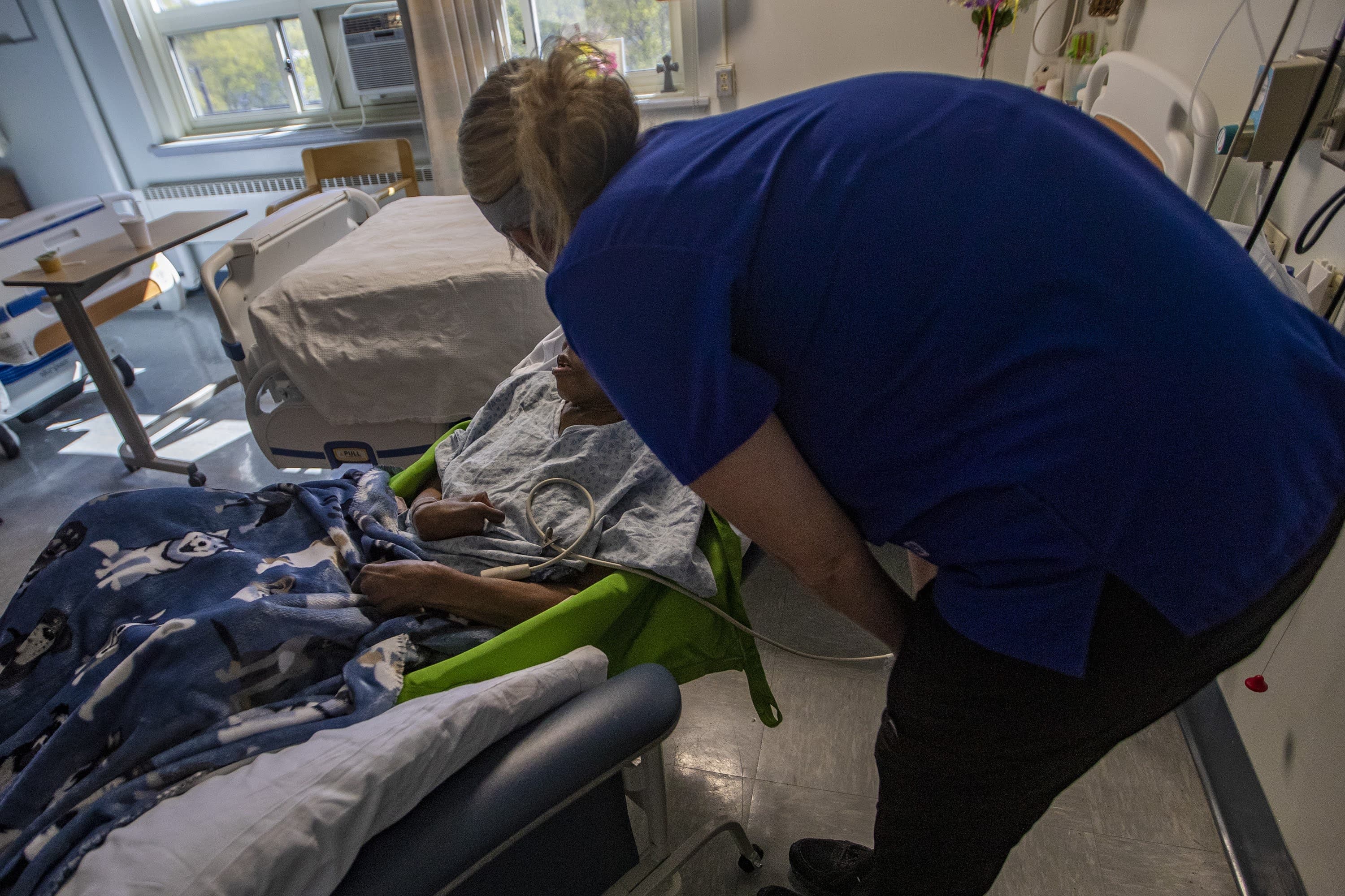 A nurse checks on Nora Ketter in her hospital room. (Jesse Costa/WBUR)