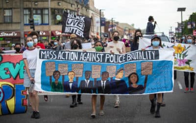 Protestors from the Mass Action Against Police Brutality rally march along Blue Hill Avenue, Boston. (Robin Lubbock/WBUR)
