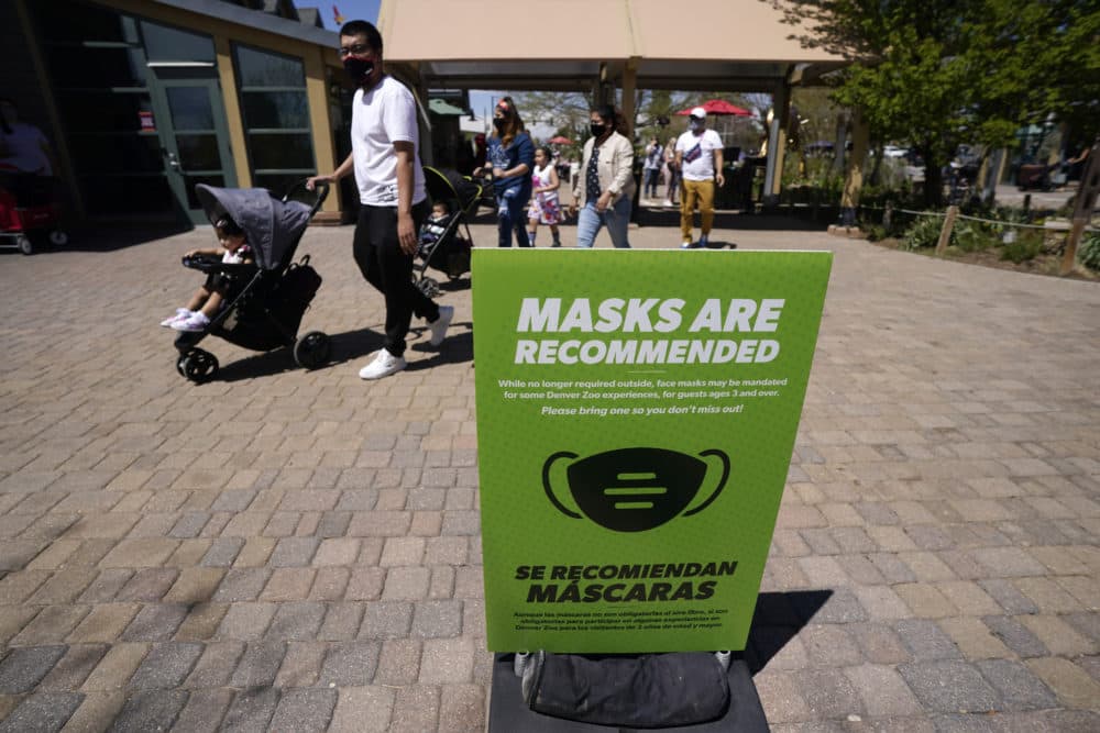 Although no longer required outside, a sign advises visitors to wear masks at the Denver Zoo in Denver on May 13, 2021. (David Zalubowski/AP)