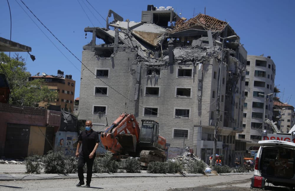 A Palestinian walks by a building hit by an Israeli airstrike in Gaza City on Tuesday, May 18. (Hatem Moussa/AP)