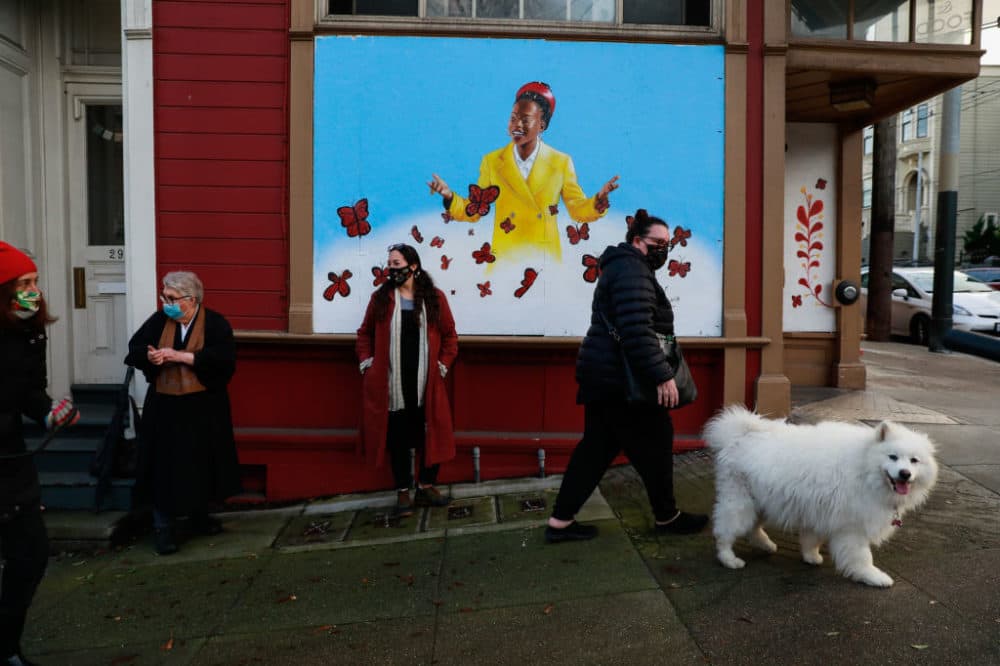 People pass by a mural of poet Amanda Gorman, painted by San Francisco muralist Nicole Hayden, center, on Page Street on Thursday, Jan. 28, 2021 in San Francisco, California. (Gabrielle Lurie/The San Francisco Chronicle via Getty Images)