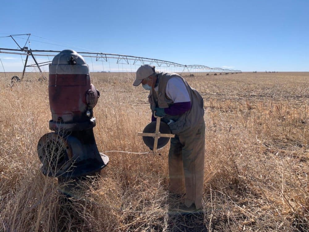 Rex Buchanan of the Kansas Geological Survey measures the aquifer's depth at a well. (David Condos/Kansas News Service)