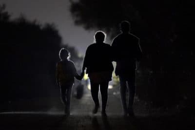A 7-year-old migrant girl from Honduras, left, walks with Fernanda Solis, 25, center, also of Honduras, and an unidentified man. They're approaching a U.S. Customs and Border Protection processing center to turn themselves in while seeking asylum, moments after crossing the U.S.-Mexico border in Mission, Texas. (Julio Cortez/AP)