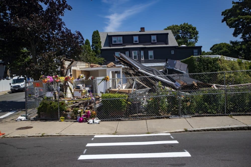 Flowers are seen on Monday in front of where Nathan Allen allegedly drove a stolen truck into a building, before shooting two people nearby in Winthrop on Saturday. (Jesse Costa/WBUR)
