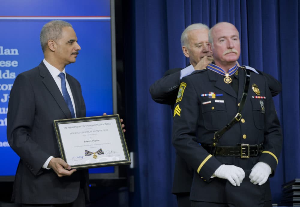 In this Feb. 11, 2015, file photo, Attorney General Eric Holder and former Vice President Joe Biden award the Medal of Valor to Sgt. Jeffrey Pugliese from the Watertown, Mass., Police Department. (Pablo Martinez Monsivais/AP)