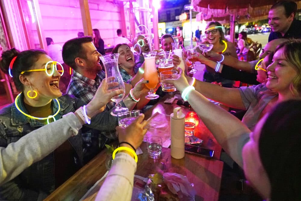 Emily Baumgartner, left, and Luke Finley, second from left, join friends in a birthday toast at the Tiki Bar on Manhattan's Upper West Side Monday, May 17, 2021, in New York. Restaurants, shops, gyms and many other businesses in New York can go back to full occupancy if all patrons are inoculated. (Kathy Willens/AP)