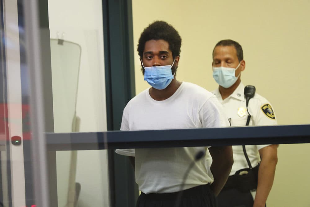 Jamhal Latimer, left, one of 11 people charged in connection with an armed standoff along I-95 last weekend, appears during his arraignment at Malden District Court on Tuesday. (Suzanne Kreiter/The Boston Globe via AP, Pool)