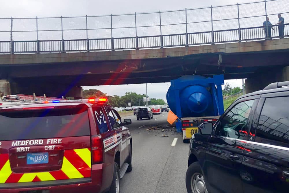 The southbound overpass on I-93 in Medford, Mass., was extensively damaged after it was hit by an oversized tractor-trailer hauling a large metal structure. (Medford Fire Department via AP)