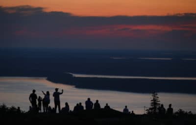 In this 2018 file photo, visitors to Acadia National Park enjoy an early sunrise near Bar Harbor, Maine. (Robert F. Bukaty/AP)