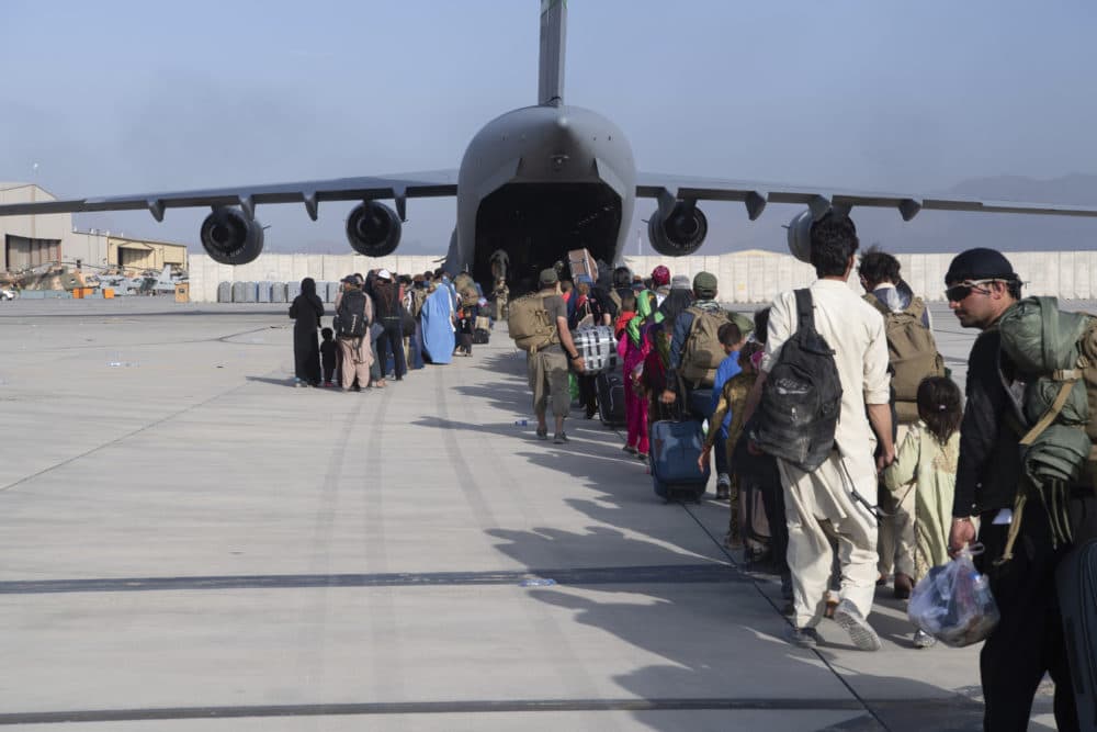 In this image provided by the U.S. Air Force, Air Force loadmasters and pilots assigned to the 816th Expeditionary Airlift Squadron load people being evacuated from Afghanistan onto a U.S. Air Force C-17 Globemaster III at Hamid Karzai International Airport in Kabul, Afghanistan, Aug. 24, 2021. (Master Sgt. Donald R. Allen/U.S. Air Force via AP)