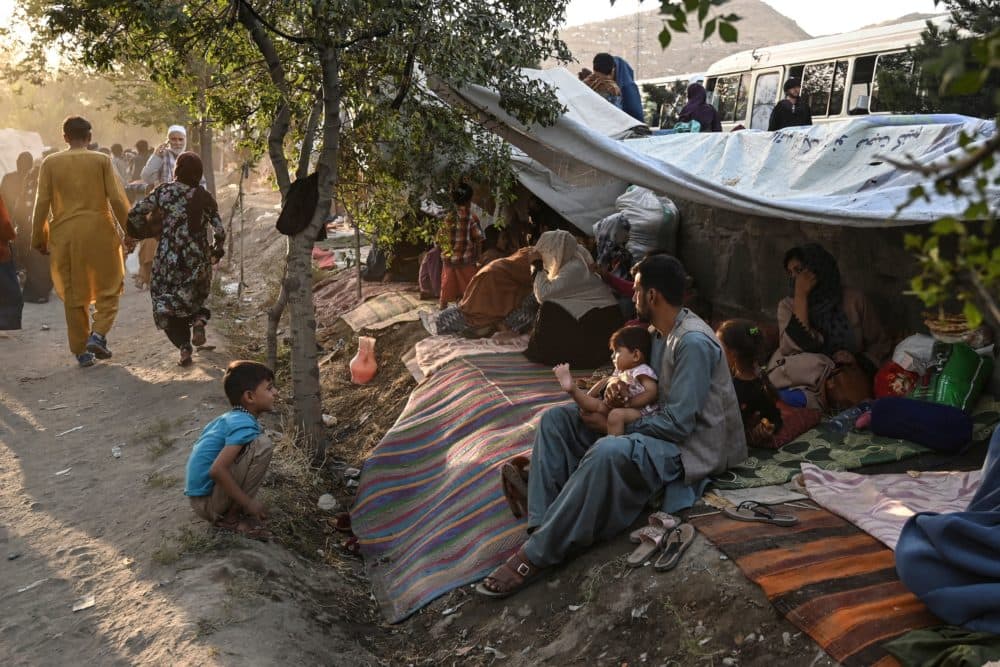 Internally displaced Afghan families, who fled from Kunduz, Takhar and Baghlan province due to battles between Taliban and Afghan security forces, sit in front of their temporary tents at Sara-e-Shamali in Kabul on August 11, 2021. (Wakil Kohsar/AFP via Getty Images)