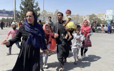 An Afghan family rushes to the Hamid Karzai International Airport as they flee the Afghan capital of Kabul, Afghanistan, on August 16, 2021. (Haroon Sabawoon/Anadolu Agency via Getty Images)