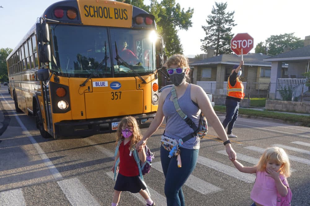 Sandra Young arrives at Whittier Elementary School with her daughters Baylin, 5, and Paytin, 2, on Tues., Aug. 24, 2021, in Salt Lake City. Kids in Salt Lake City are headed back to school wearing masks after the mayor issued a mandate order despite heavy restrictions on mask mandates imposed by the GOP-dominated Legislature. (Rick Bowmer/AP)