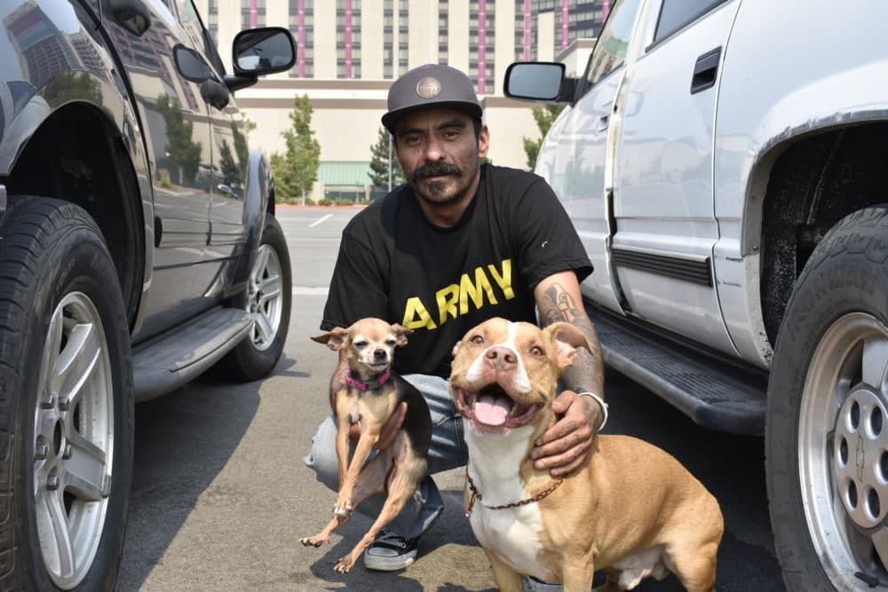 South Lake Tahoe resident Jose Mora was relocated from the American Red Cross’ evacuation center at the Carson City Community Center to the Reno-Sparks Convention Center with his family and two dogs, Lady (right) and Woody, on Sept. 1, 2021. (Lucia Starbuck/KUNR Public Radio)