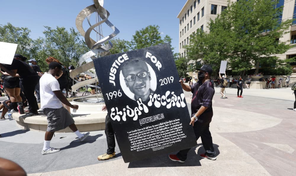 June 27, 2020: Demonstrators carry a giant placard during a rally and march over the death of Elijah McClain outside the police department in Aurora, Colo. (David Zalubowski/AP)