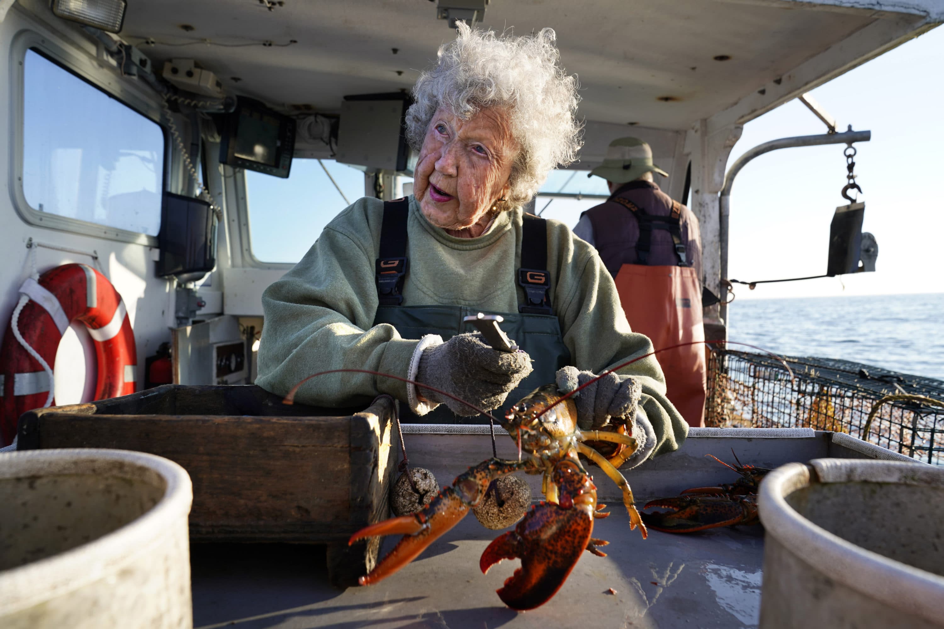 Virginia Oliver, age 101, works as a sternman, measuring and banding lobsters on her son Max Oliver's boat, Aug. 31, 2021, off Rockland, Maine. The state's oldest lobster harvester has been doing it since before the onset of the Great Depression. (Robert F. Bukaty/AP)