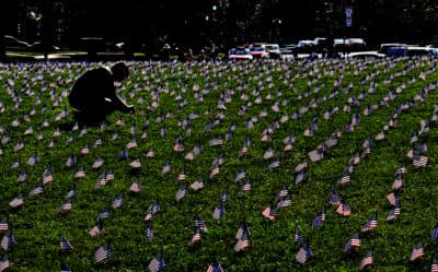 More than 5,000 American flags were planted on a grassy area of the National Mall, each representing a veteran or a service member who died by suicide through early October 2018, an average of 20 suicides per day. Ryan Conklin straightens some flags at the site. Conklin is an Iraq and Afghanistan (U.S. Army) veteran who lost several comrades and a close friend to suicide. (Michael S. Williamson/The Washington Post via Getty Images)