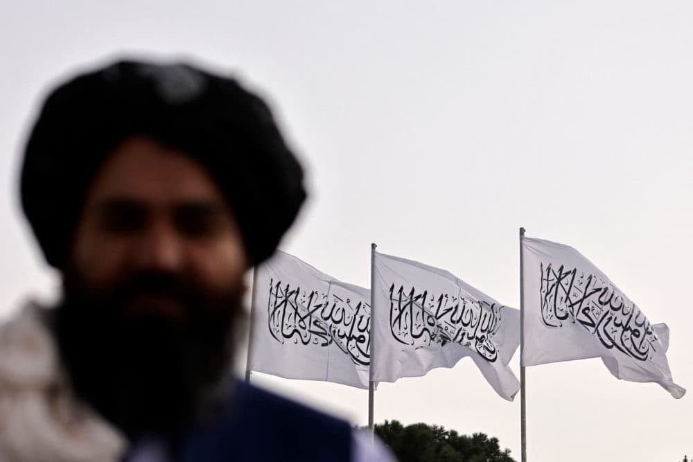 A Taliban fighter is pictured against the backdrop of Taliban flags installed at the Hamid Karzai International Airport in Kabul on Sept. 11, 2021. (Karim Sahib/AFP via Getty Images)
