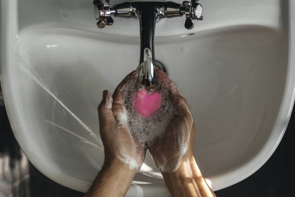 A person washing their hands with heart shaped soap. (Getty Images)