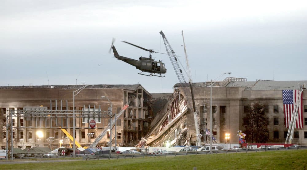 A military helicopter flies in front of the Pentagon September 14, 2001 in Arlington, Virginia at the impact site where a hijacked airliner crashed into the building. (Stephen J. Boitano/Getty Images)