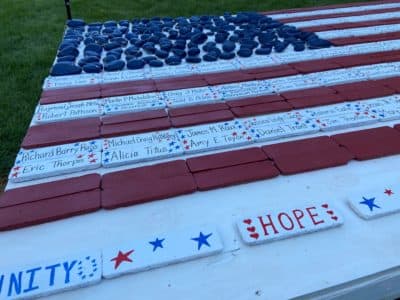 An American flag memorial, created by younger volunteers at an event on the Rose Kennedy Greenway, bears the names of 9/11 victims with ties to Massachusetts. (Quincy Walters/WBUR)