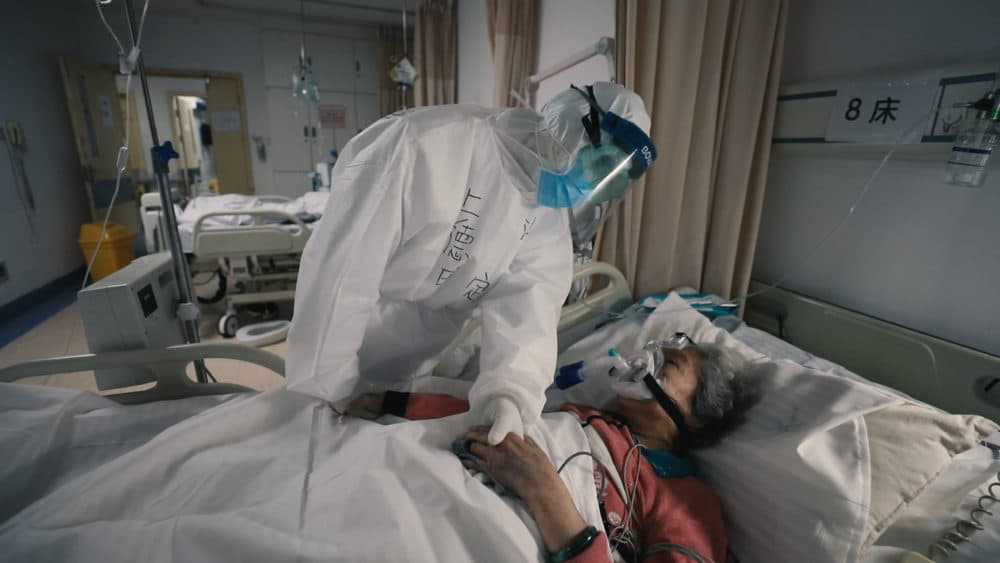 Elderly female patient of COVID-19 on a respirator being comforted by a doctor in Wuhan, China. As seen in &quot;76 Days&quot; directed by Hao Wu, Weixi Chen and Anonymous. (MTV Documentary Films_