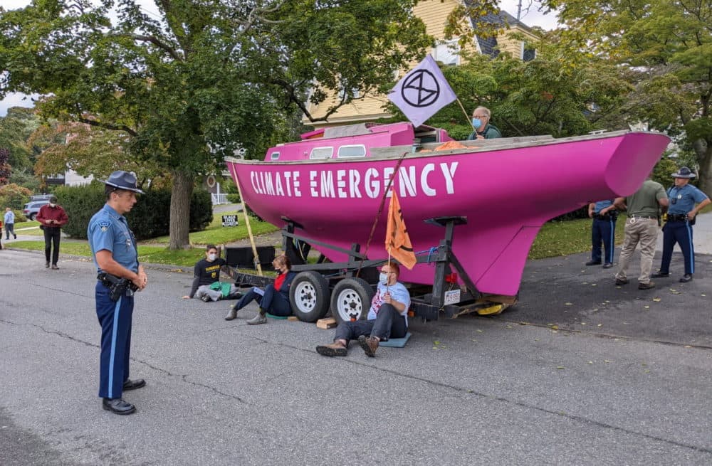 State troopers surround climate protesters and their pink vessel, christened &quot;Climate Emergency,&quot; at the end of Gov. Charlie Baker's driveway on the morning of Sept. 28. (Courtesy Extinction Rebellion via Twitter)