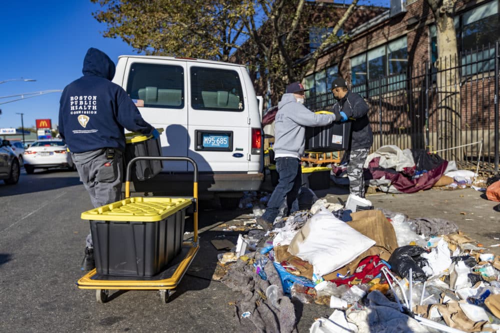 Boston Public Health Commission workers load bins full of belongings into a van on Southampton Street during the clearing out of people living in tents in the &quot;Mass. and Cass&quot; area. They will be taken to a storage facility and held onto for up to 90 days. (Jesse Costa/WBUR)