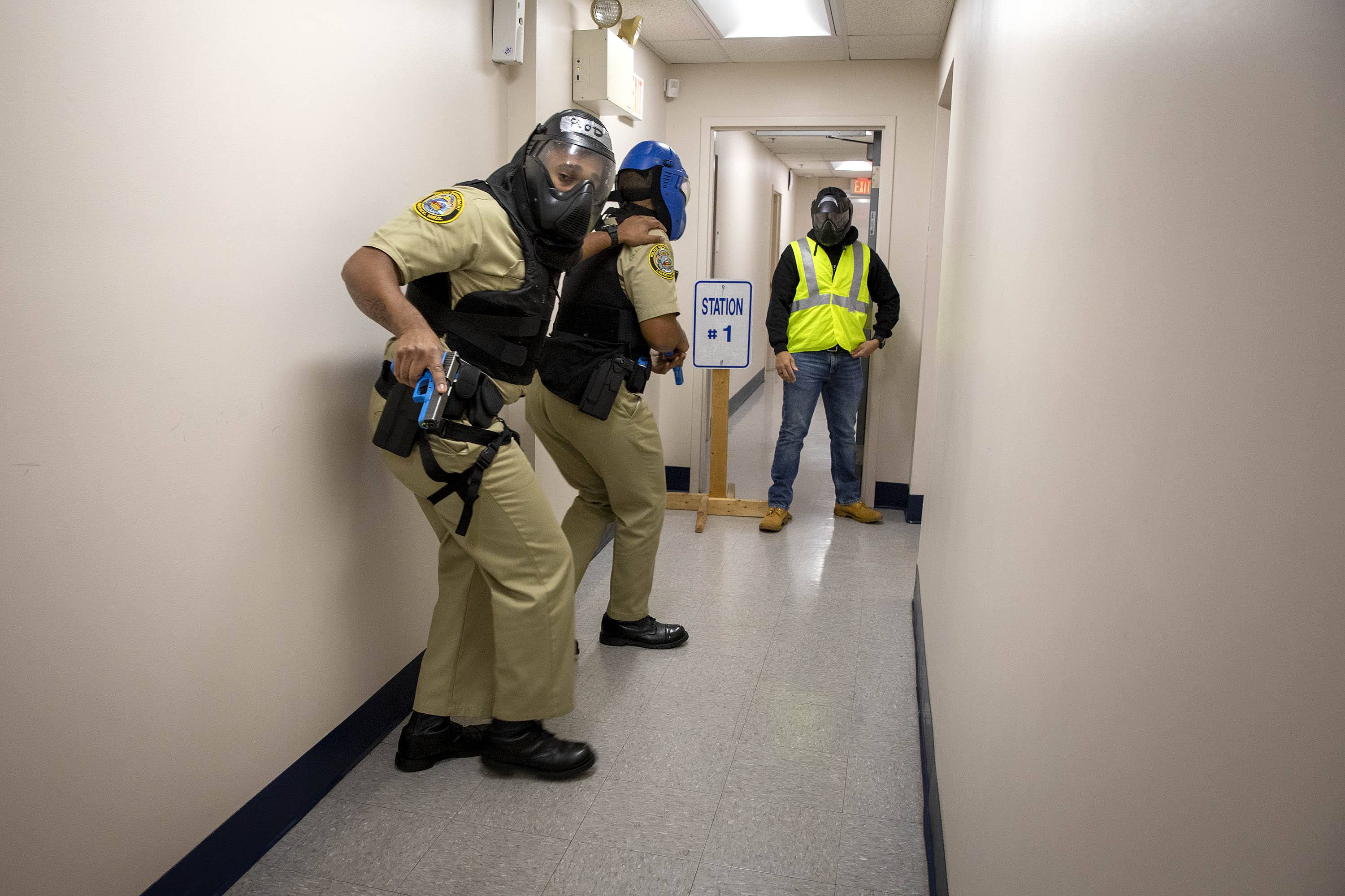 During a police academy training session two student officers, observed by an instructor, search a building for an armed person. (Robin Lubbock/WBUR)