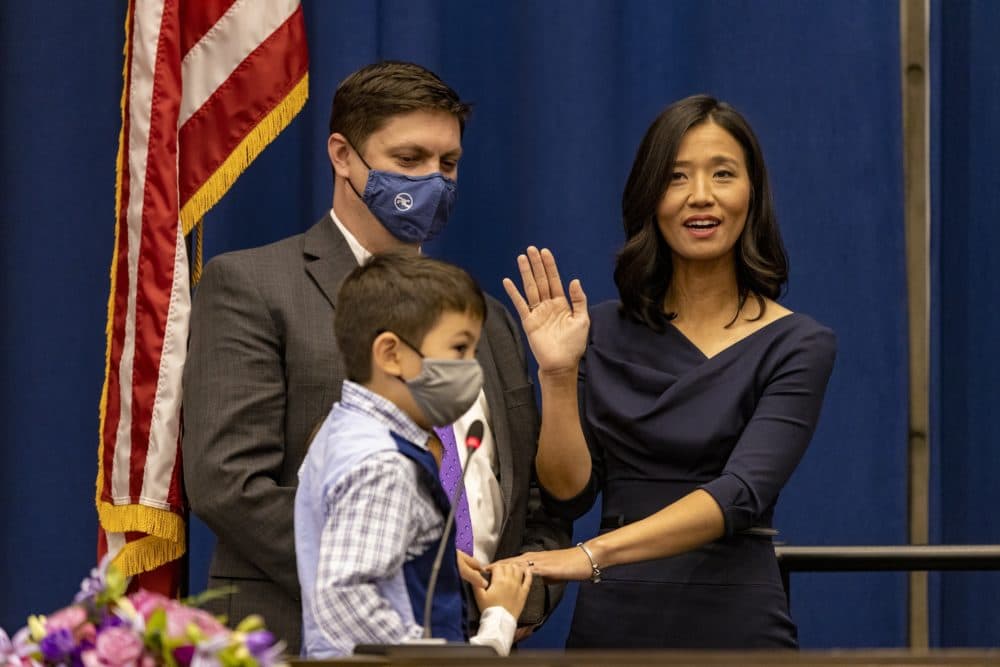 With her family by her side, Michelle Wu takes the oath as the next mayor of Boston in the Boston City Council Chamber. (Jesse Costa/WBUR)