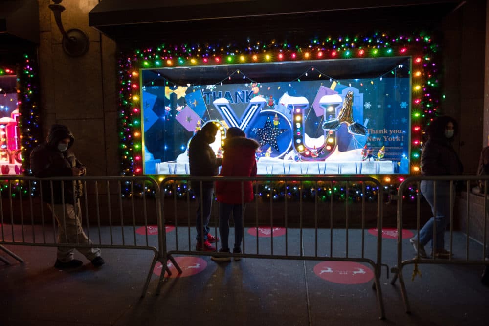 People wearing masks wait in front of Macy's holiday windows for Black Friday deals on November 27, 2020 in New York City. ￼Unlike previous years, many retail stores will remain closed on Thanksgiving day in an effort to avoid overcrowding due to the pandemic. (Alexi Rosenfeld/Getty Images)