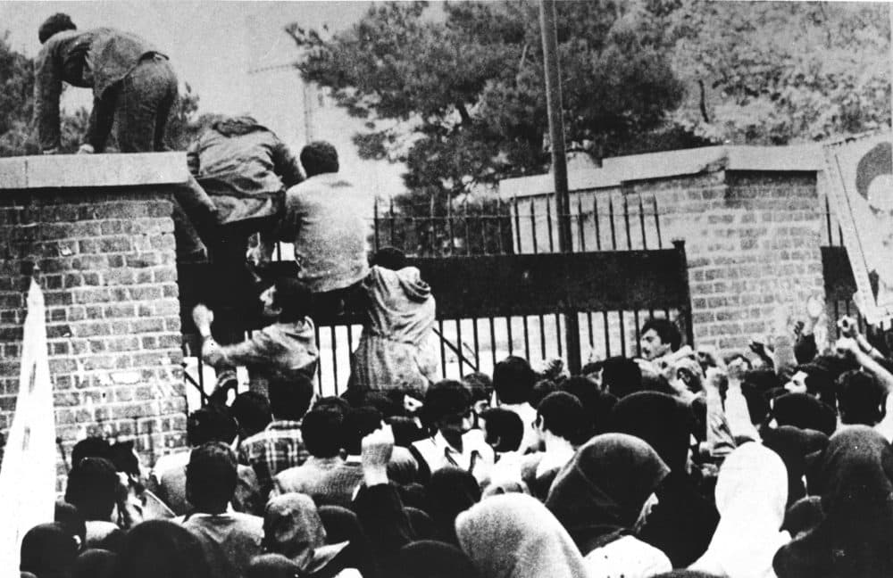 Iranian students climb over the wall of the U.S. embassy in Tehran on Nov. 4, 1979. (STR/AFP via Getty Images)