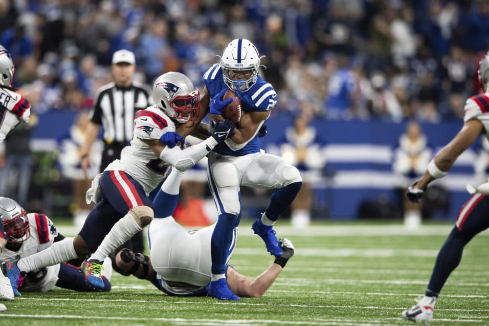 New England Patriots defensive back Adrian Phillips (21) tackles Indianapolis Colts running back Jonathan Taylor (28) during an NFL football game, Saturday, Dec. 18, 2021, in Indianapolis. (AP Photo/Zach Bolinger)