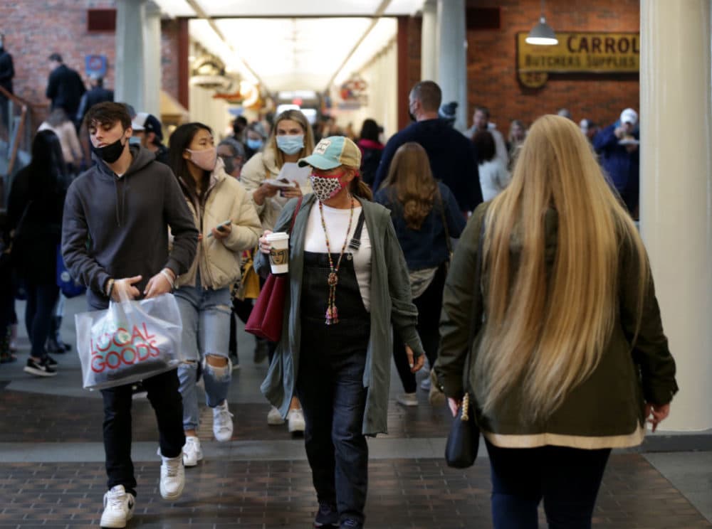 Some visitors to Faneuil Hall Marketplace with their masks and some without in Boston on May 29, 2021 as Massachusetts operates under the new Covid-19 restrictions, including the mask mandate, being lifted. (Jonathan Wiggs/The Boston Globe via Getty Images)