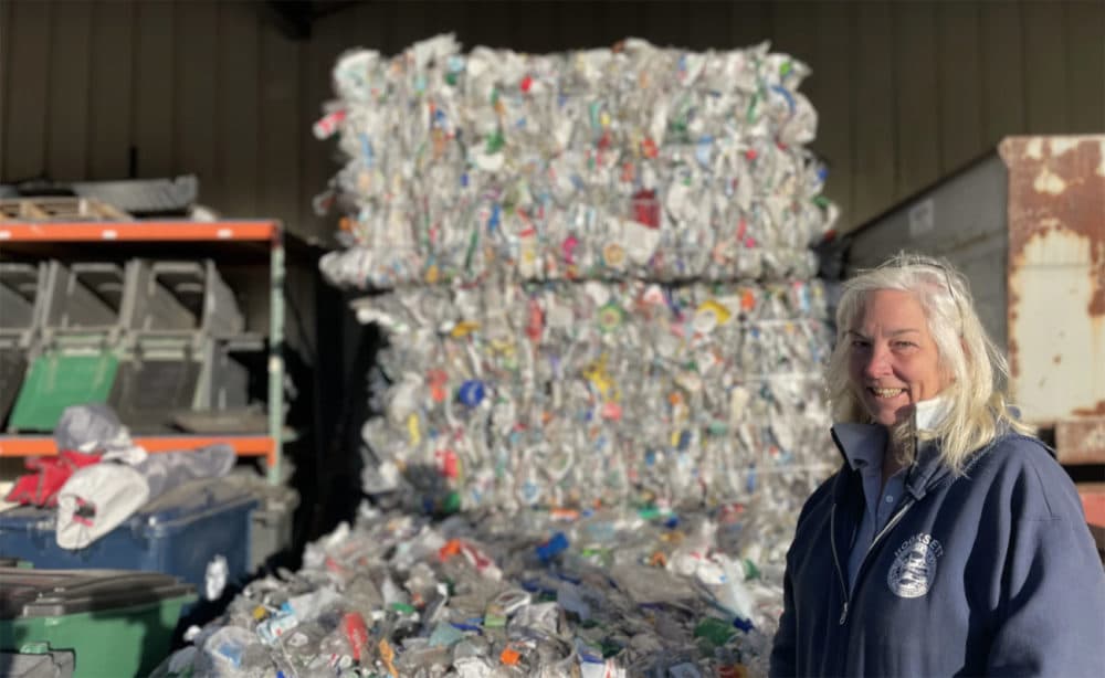 Denise Cumings, crew chief, stands in front of a bale of recycling at the Hooksett Transfer Station. (Mara Hoplamazian for NHPR)
