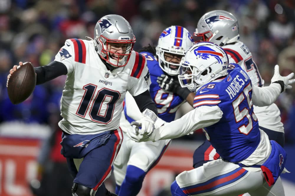 New England Patriots quarterback Mac Jones runs the ball under pressure from the Buffalo Bills defense during the first half of an NFL wild-card playoff football game Saturday in Orchard Park, N.Y. (Joshua Bessex/AP)