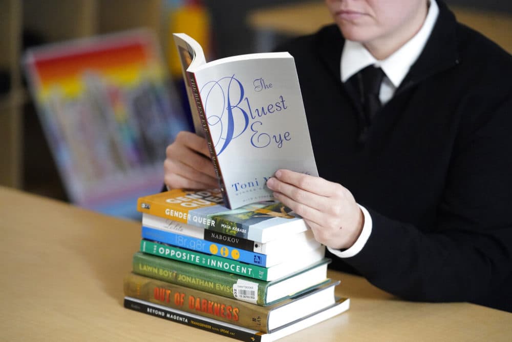 Amanda Darrow, director of youth, family and education programs at the Utah Pride Center, poses with books that have been the subject of complaints from parents in recent weeks on Thursday, Dec. 16, 2021, in Salt Lake City.   (Rick Bowmer/AP)