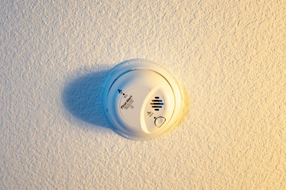 A combination smoke detector and carbon monoxide detector installed on a ceiling. (Smith Collection/Gado/Getty Images)