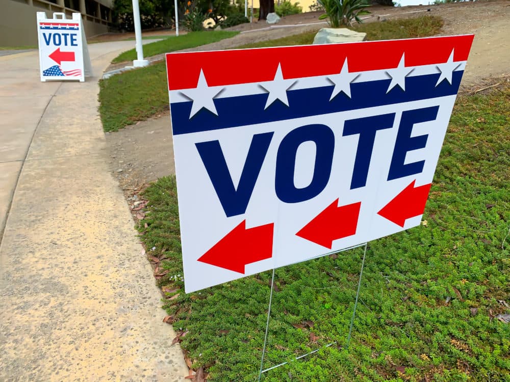 Red, white and blue sign with an arrow indicating where to go to vote. (Getty images)