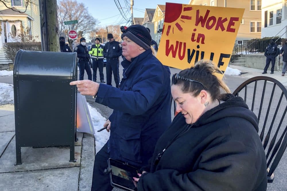 Rob Burke and Catherine Vitale protest outside of Boston Mayor Michelle Wu's home in Roslindale. (Anthony Brooks/WBUR)