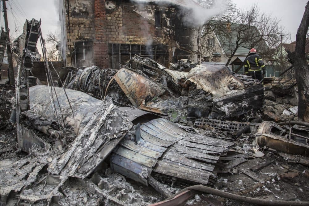 A Ukrainian firefighter walks between at fragments of a downed aircraft seen in in Kyiv, Ukraine, Friday, Feb. 25, 2022. It was unclear what aicraft crashed and what brought it down amid the Russian invasion in Ukraine Russia is pressing its invasion of Ukraine to the outskirts of the capital after unleashing airstrikes on cities and military bases and sending in troops and tanks from three sides. (Oleksandr Ratushniak/AP)