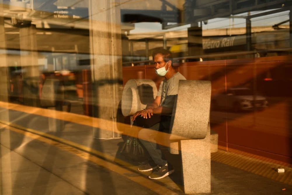 A transit passenger wears a face mask as they wait to board the Metro C Line, formerly Green Line, light rail train alongside the 105 Freeway at the Judge Harry Pregerson Interchange during rush hour traffic in Los Angeles, California on July 16, 2021.  (Patrick T. Fallon/AFP via Getty Images)