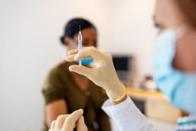 Doctor preparing coronavirus injection. (Louis Alvarez/Getty Images)